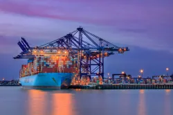 Sunset image of container ship Marseille Maersk at berth in Felixstowe Docks, Suffolk UK on 7th October 2018. Unloading under a colourful sunset sky with starburst light effects on the cranes and dock